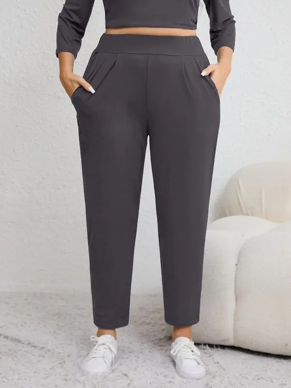 Plus-size solid color pleated sweatpants with an elastic waistband, featuring a casual, sporty style and a high-waisted design.