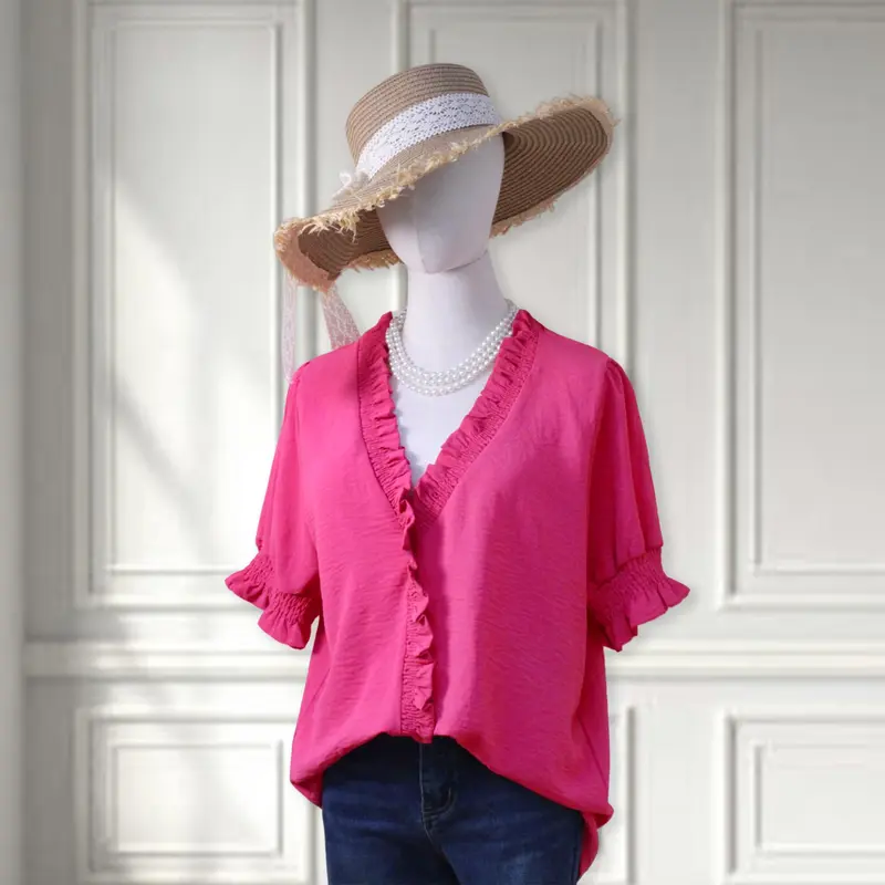 A bright pink V-neck shirt with ruffled details, featuring pleats at the cuffs and front, made of soft fabric.
