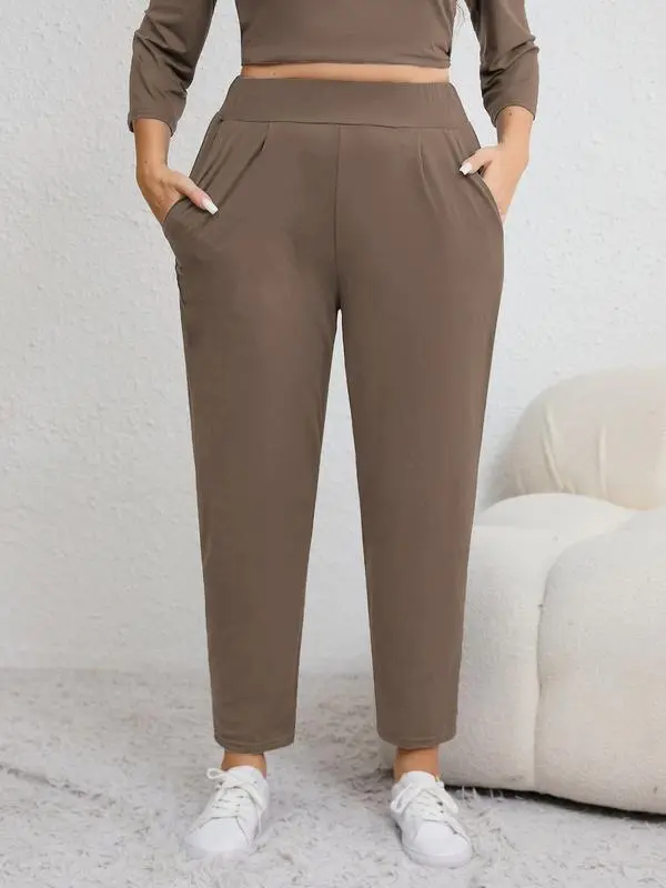 Plus-size solid color pleated sweatpants with an elastic waistband, featuring a casual, sporty style and a high-waisted design.